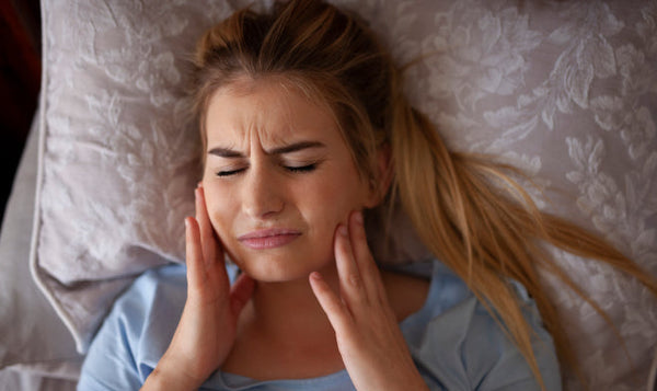  How does teeth grinding cause gum recession?